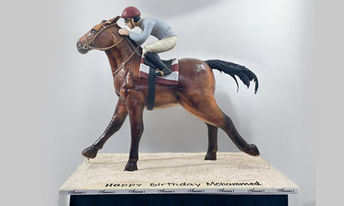 Realistic horse and rider birthday cake with detailed sculpted figure and stable-inspired base.