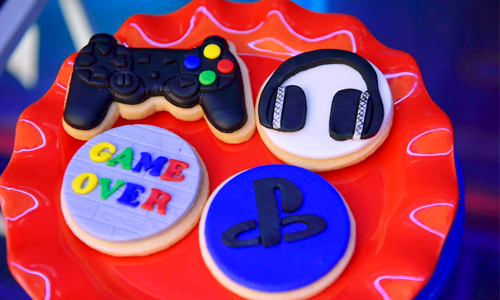 Red gaming-themed cookies featuring PlayStation controller and headset details.