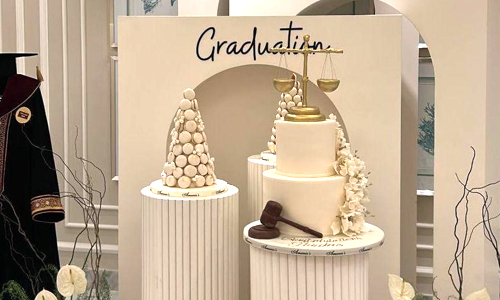 Graduation dessert table featuring a custom graduation cake, macaron tower, and coordinated sweets arranged for a graduation celebration. For Law school