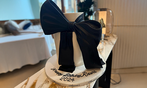 Customized women�fs cake featuring a bold black bow design with minimalist styling and smooth fondant finish.